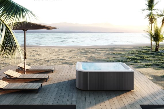 A hot tub on a wooden deck overlooking the beach and ocean