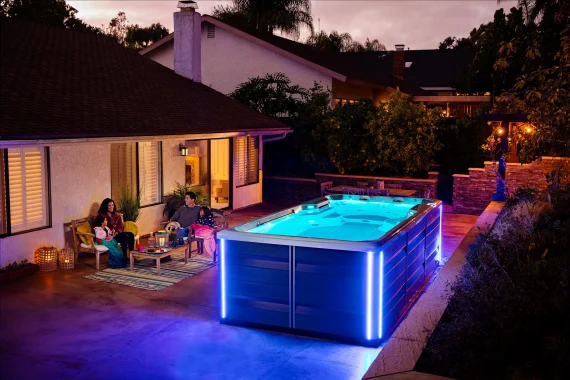 Family relaxing on chairs by the swimming pool against the current at night